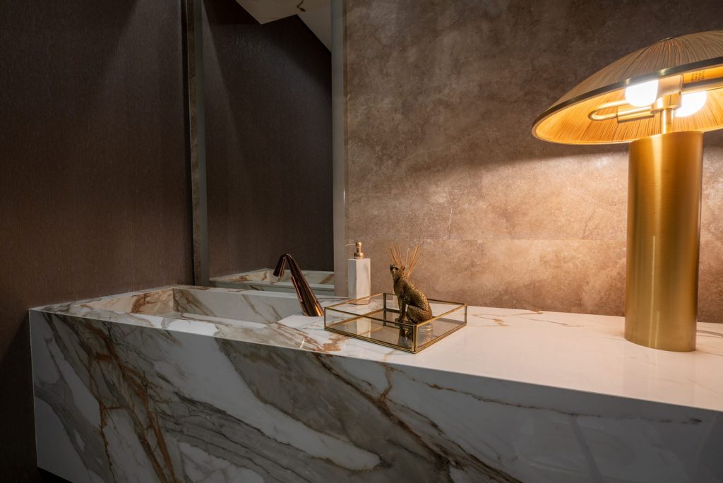 Altın ve gri damarlı Ascale Macchia Vecchia Gold porselen tezgah ve entegre lavabo ile tasarlanmış lüks banyo dekorasyonu.
