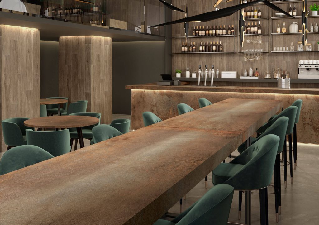 Paslanmış metal efektli Ascale Moma Rusteel porselen tezgah ve masaların kullanıldığı şık ve modern restoran tasarımı.