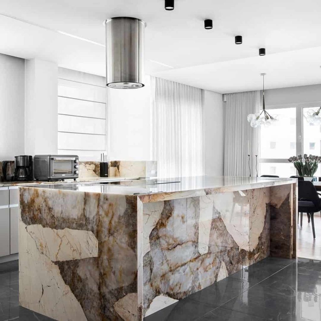 Ascale Patagonia Gold porselen levha ile tasarlanmış, altın ve bej damarlı, şelale kenarlı modern mutfak adası ve tezgahı.