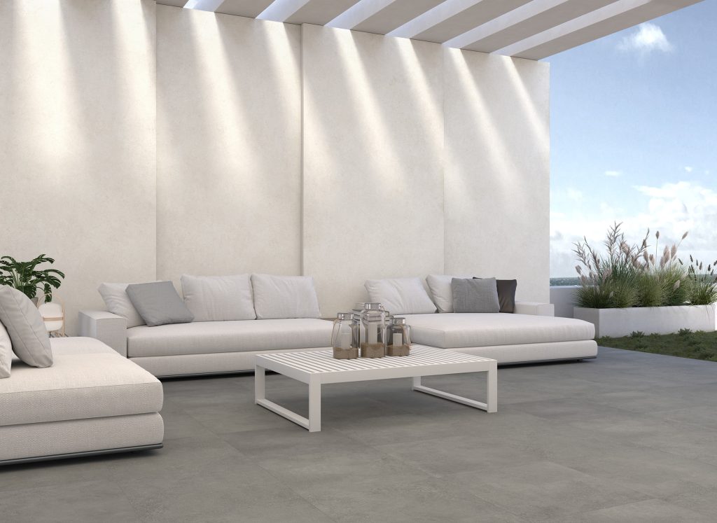 Ascale Urban White porselen plakalarla kaplanmış dış cephe duvarı ve gri zeminli modern teras alanı.