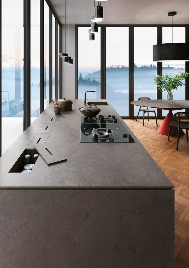Gri, doğal taş dokulu Infinity Buxy Select porselen tezgah ve şelale kenarlı modern mutfak adası uygulaması.