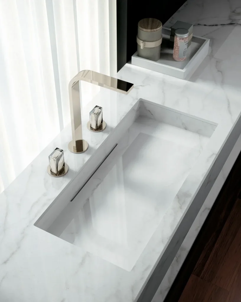 Beyaz zemin üzerine gri damarlı Infinity Calacatta Lincoln porselen banyo tezgahı ve yekpare lavabo uygulaması.
