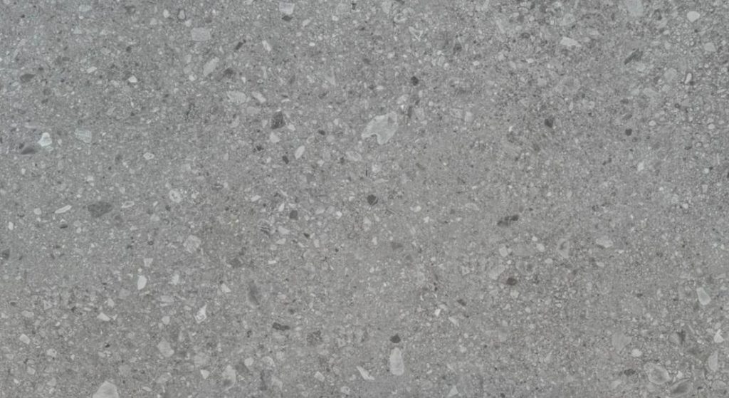 Marazzi Ceppo Di Gre porselen tezgahın gri zemin üzerine farklı tonlarda çakıl parçacıkları içeren terrazzo dokusu.