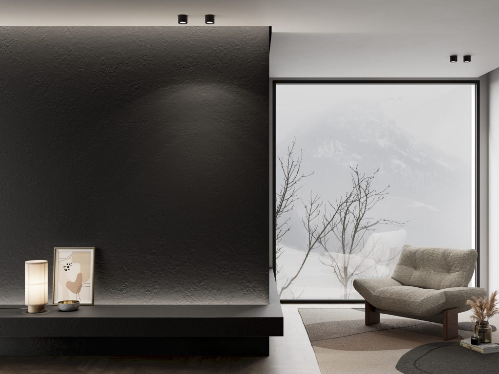 Dokulu yüzeyli Lapidura Absolute Black porselen plakanın modern bir salonda duvar ve konsol olarak uygulanması.