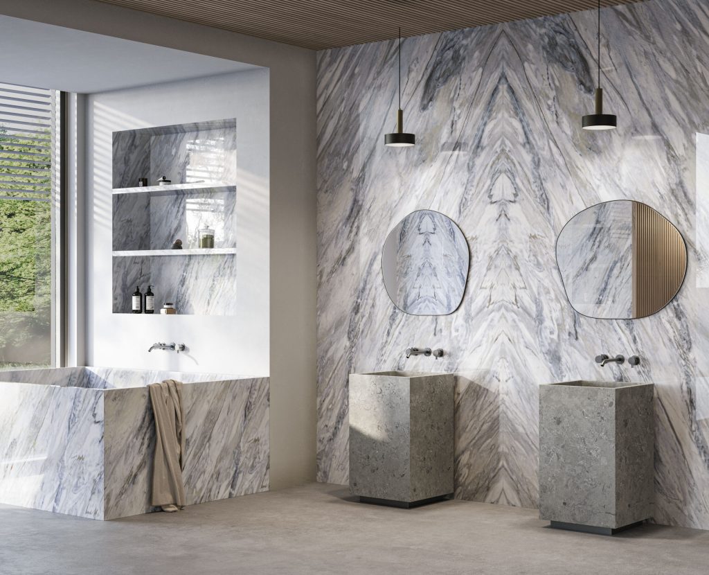 Bookmatch uygulanmış Lapidura Calacatta Manhattan porselen plaka ile kaplı lüks banyo duvarı ve küvet.