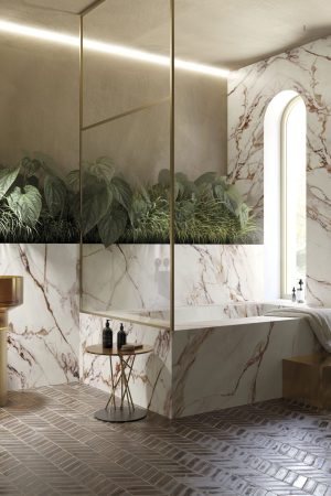 Kırmızı ve altın damarlı Light Red Calacatta porselen ile kaplı lüks banyo duvarı, küvet ve altın rengi lavabolar.