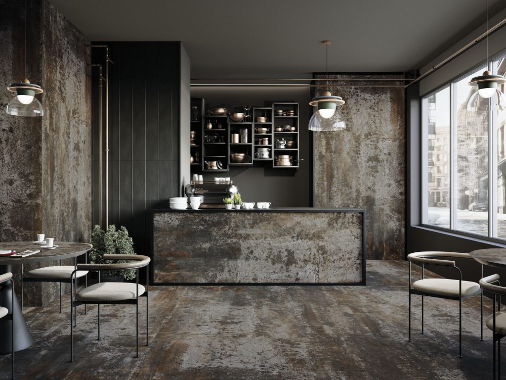 Endüstriyel kafe tasarımında kullanılan paslanmış metal görünümlü Lapidura Midnight Corten porselen duvar, zemin ve tezgah.