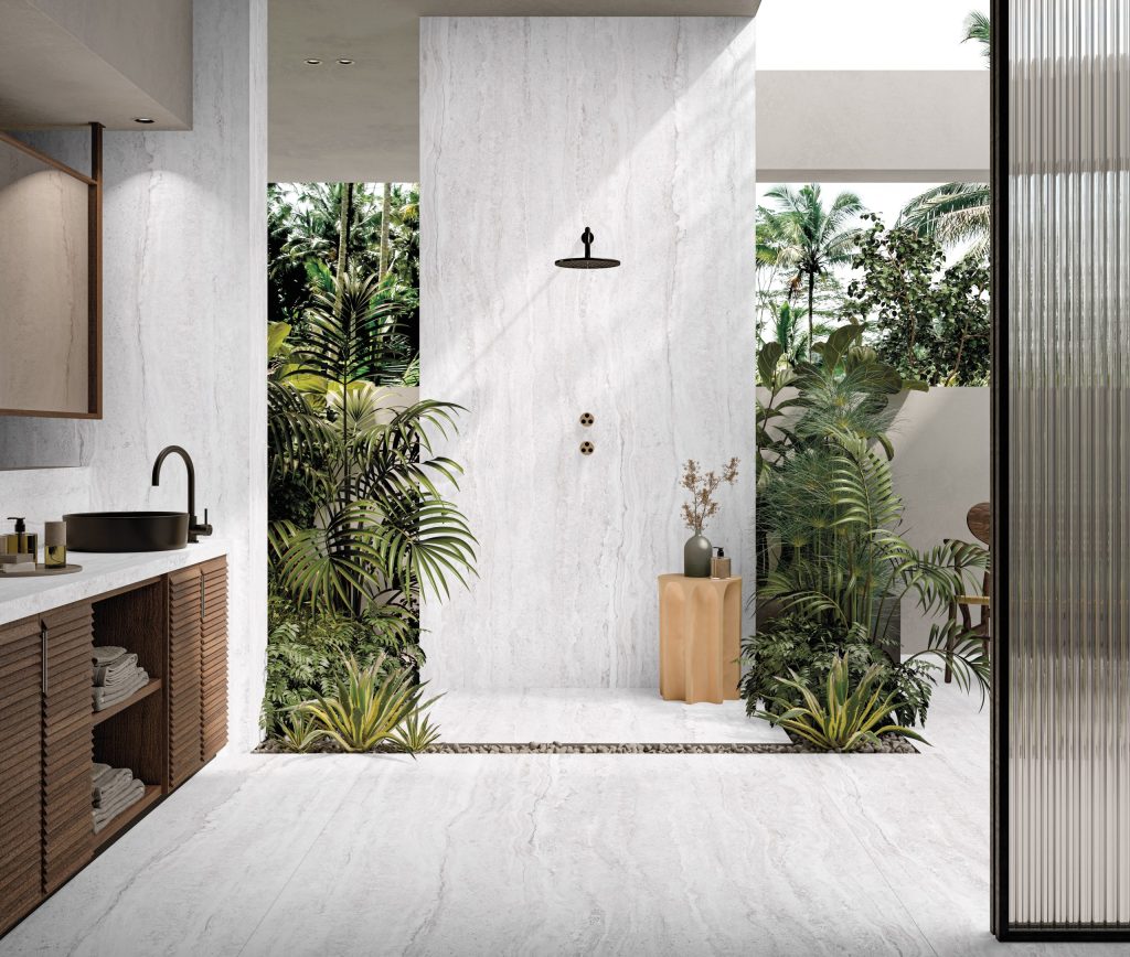 Traverten dokulu beyaz porselen zemin ve duvar kaplaması kullanılan, ahşap dolaplı ve bitkili modern banyo tasarımı.