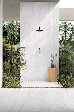 Traverten dokulu beyaz porselen zemin ve duvar kaplaması kullanılan, ahşap dolaplı ve bitkili modern banyo tasarımı.